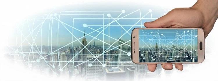 A hand holding a mobile phone connecting to a smart city