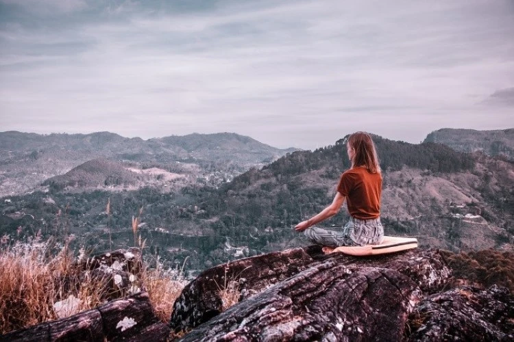 A woman meditating on the mountain top